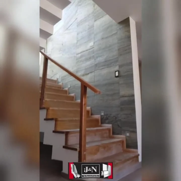 Baranda de escalera en vidrio laminado de seguridad con pasamanos de madera - obra de J&N Aluminio en Neuquén