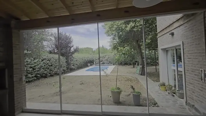 La galería cerrada con cristal frente a la pileta