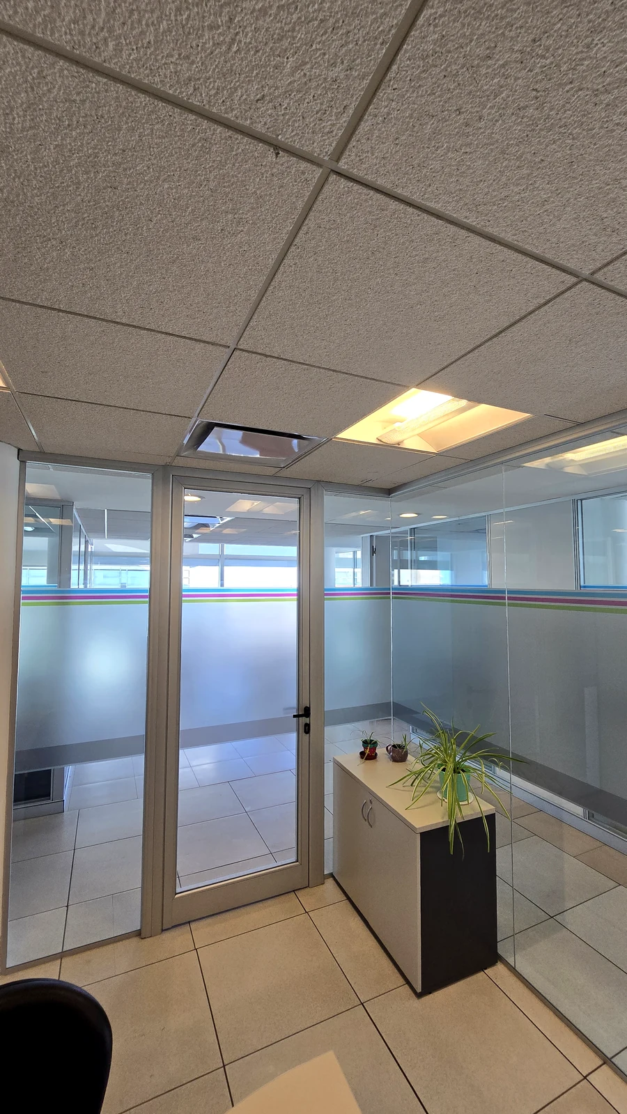 Acceso vidriado a oficina con puerta de aluminio y cantero interior