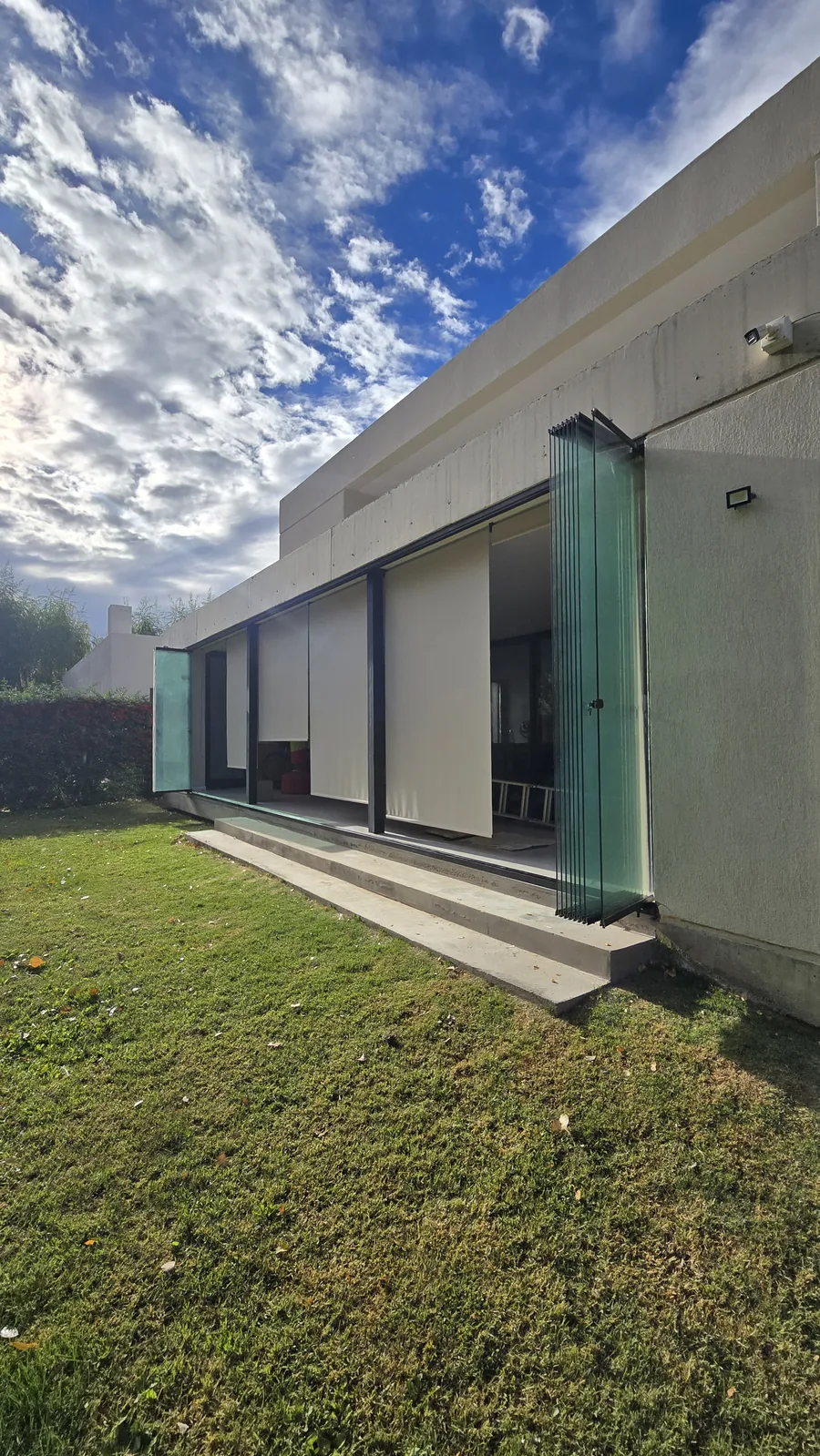 Cortina de cristal abierta con los paños plegados en el extremo de la galería - JN Aluminio Neuquén