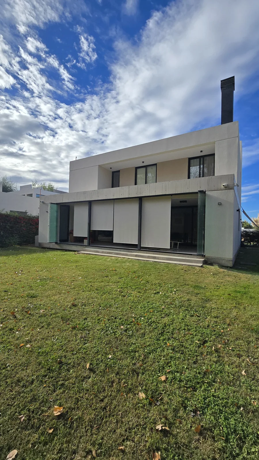 Cerramiento de cristal templado cerrado en galería de casa moderna en Neuquén - JN Aluminio