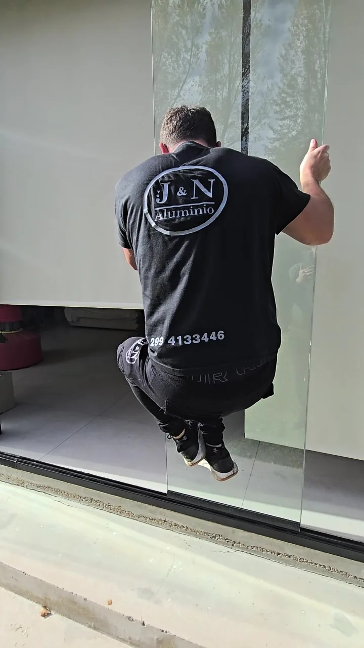 Prueba de resistencia: operario de 85 kg colgado de una cortina de cristal instalada por JN Aluminio en Neuquén