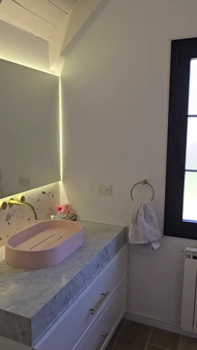 Espejo retroiluminado en un baño de terrazo