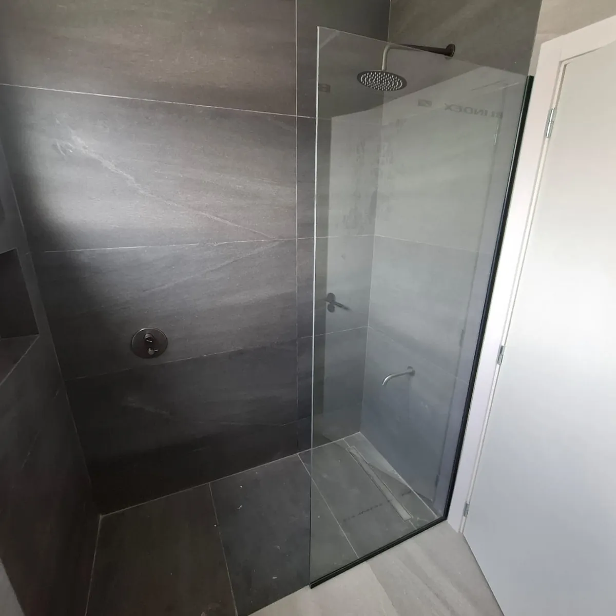 Mampara de paño fijo con perfil de aluminio tipo U en L y vidrio laminado Blindex 4+4 - obra de J&N Aluminio en Neuquén