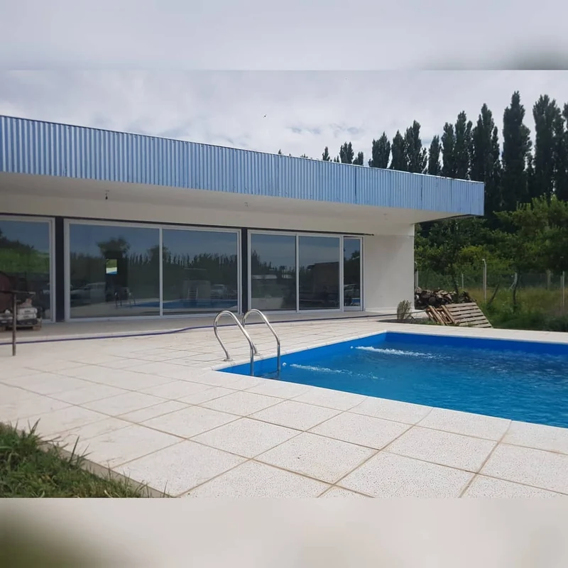 Galería con cerramiento vidriado de piso a techo frente a la pileta - obra de JN Aluminio en Neuquén