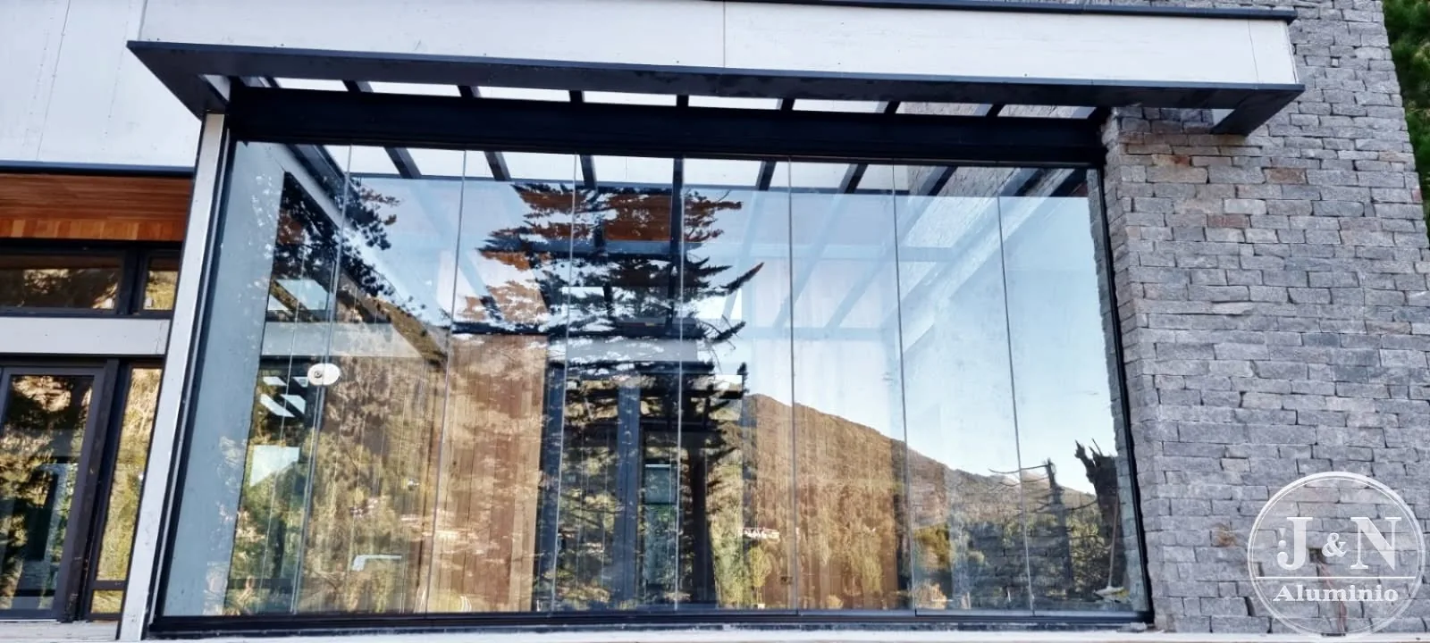 Cortina de cristal frameless en casa de montaña - obra de J&N Aluminio en Bahía Manzano, Villa La Angostura
