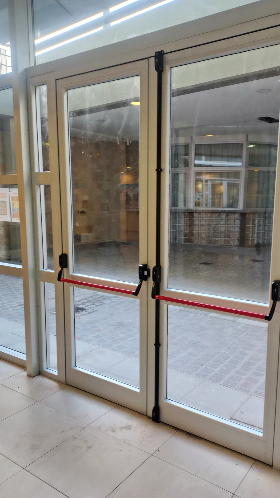 Barral antipánico rojo instalado en la puerta doble de acceso del Poder Judicial de Neuquén
