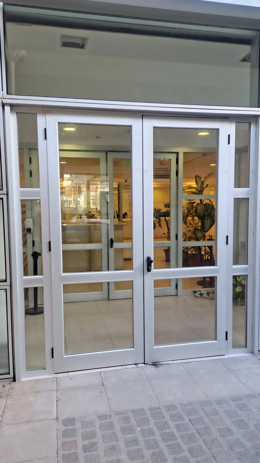 Puerta doble de aluminio y vidrio en el acceso principal del Poder Judicial de Neuquén, fabricada por J&N Aluminio