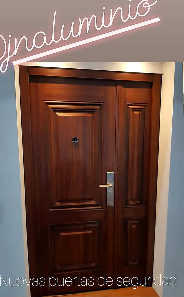 Puerta de seguridad multianclaje símil caoba con tableros en el showroom de J&N Aluminio, Neuquén
