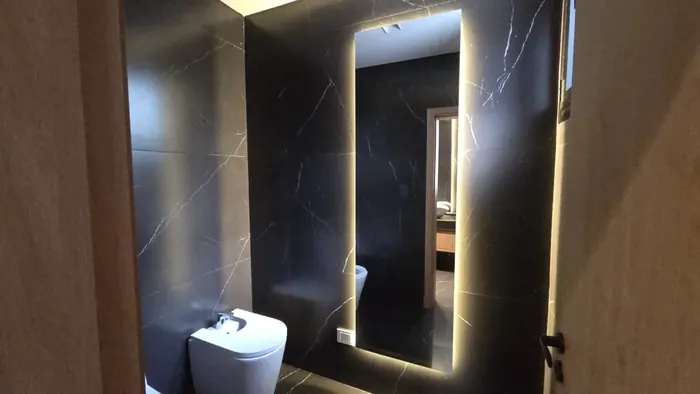 Espejo LED retroiluminado en baño de mármol oscuro