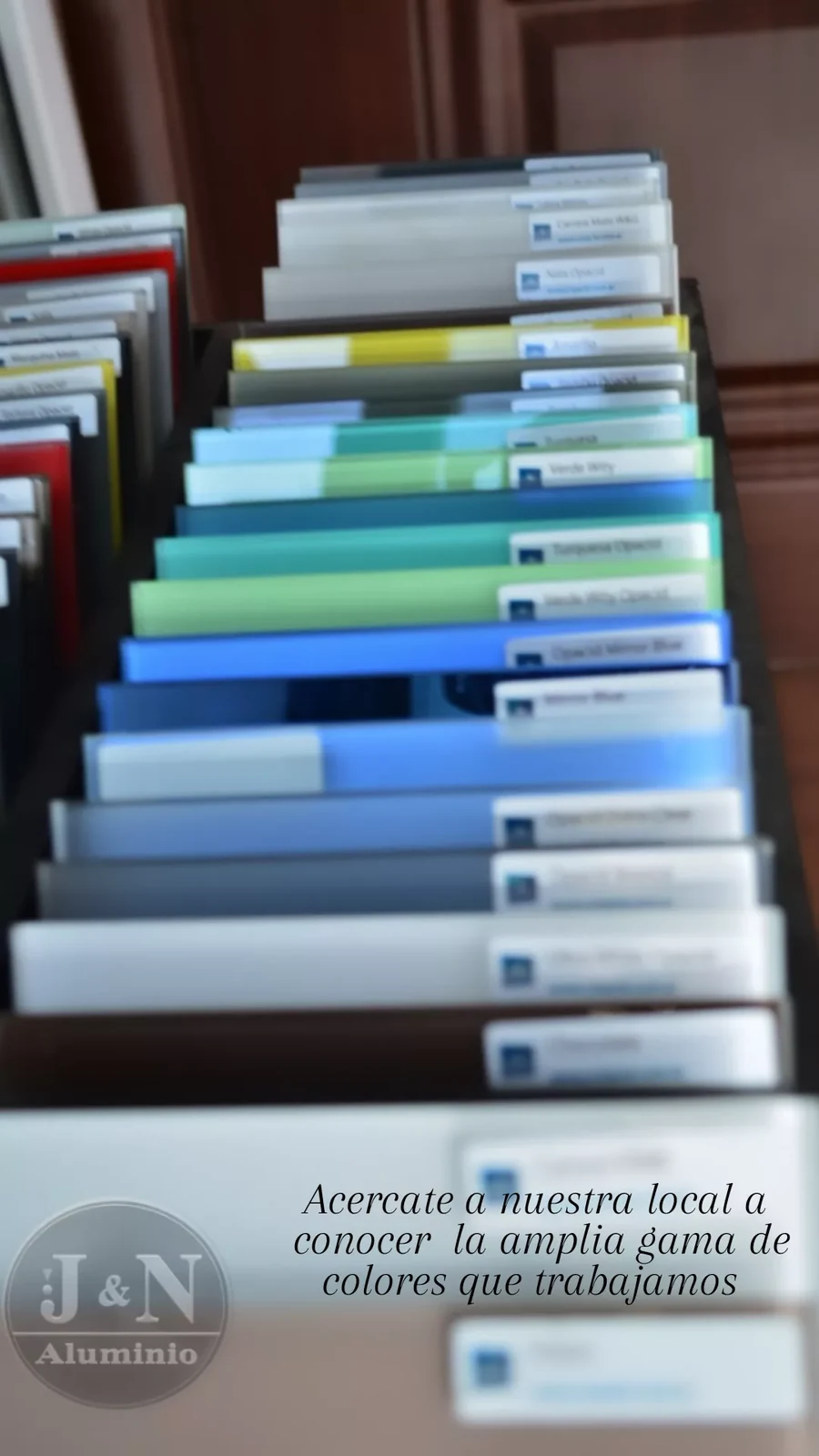Muestrario de placas de vidrio de color con sus referencias, en el local de J&N Aluminio en Neuquén